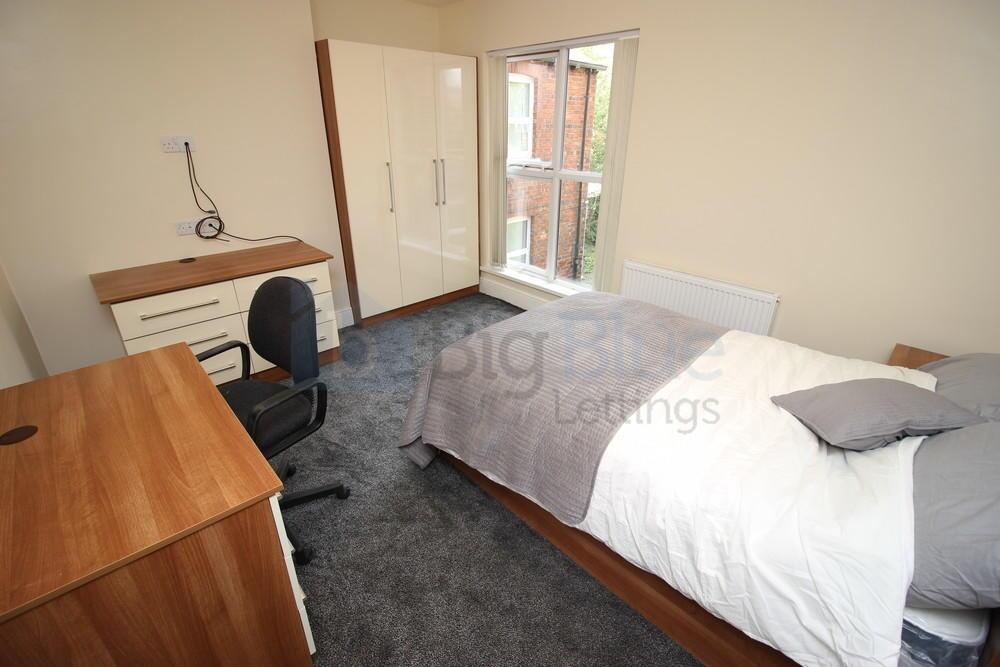 A bright and tidy master bedroom featuring a co...