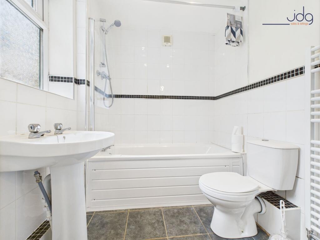 Fully tiled ground floor bathroom with overhead shower