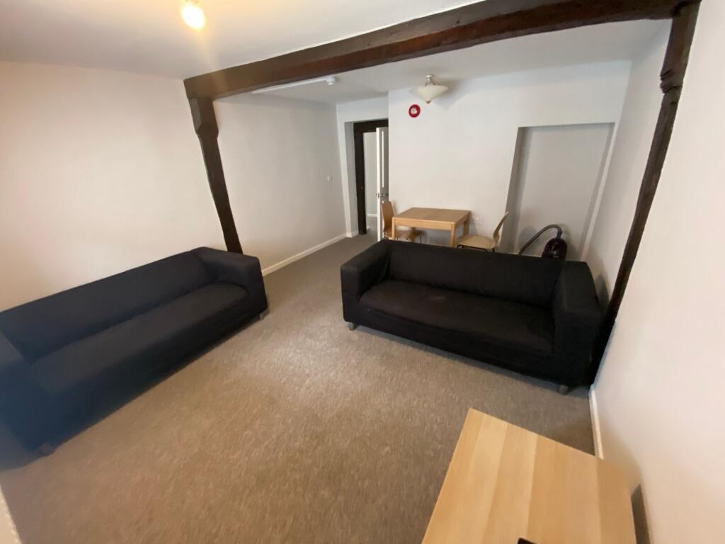 A cozy living room featuring two black sofas fa...