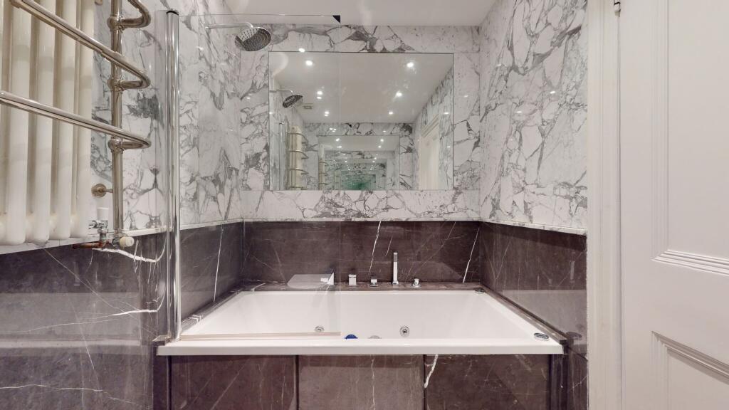 A stylish bathroom suite featuring a large bath...