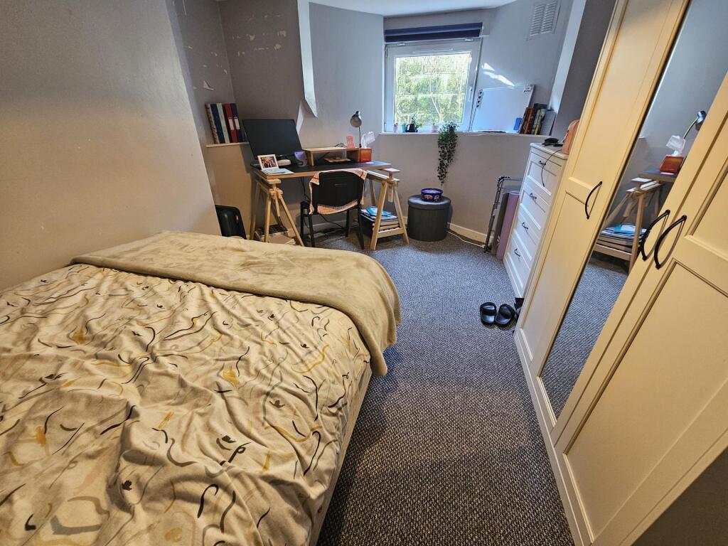 Cozy single bedroom with a window providing nat...