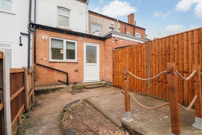 A neatly maintained private garden with a paved...