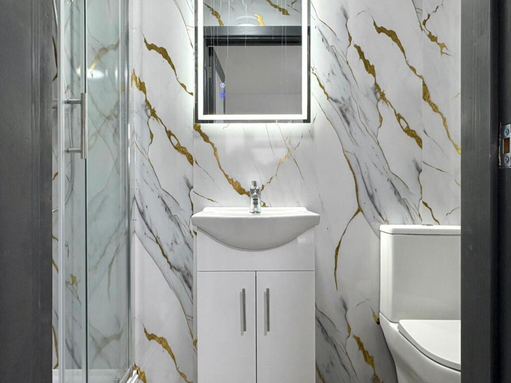 Contemporary bathroom with marble-effect wall t...