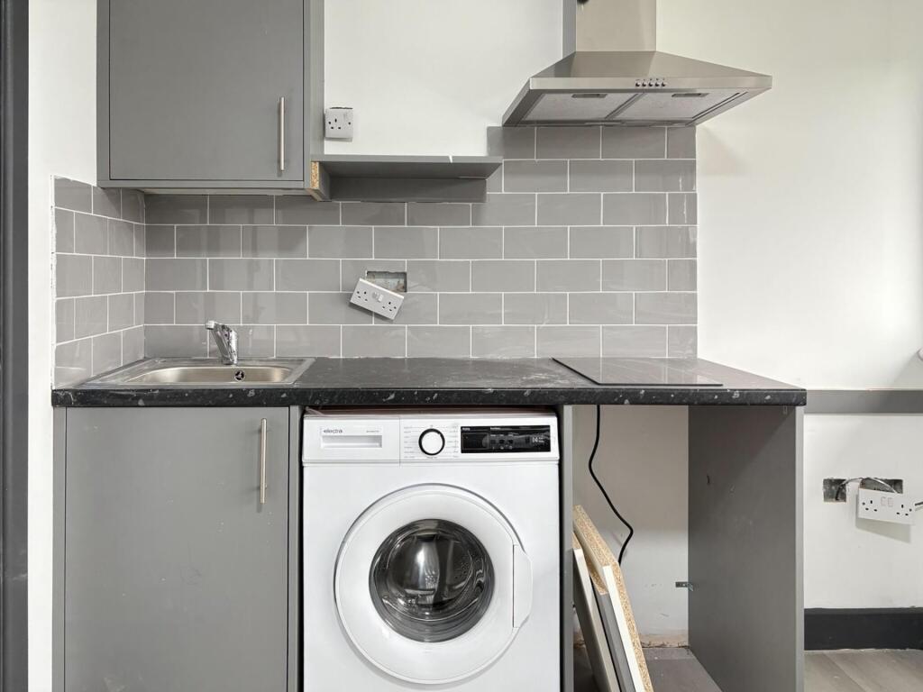 Compact modern kitchenette with grey cabinets, ...