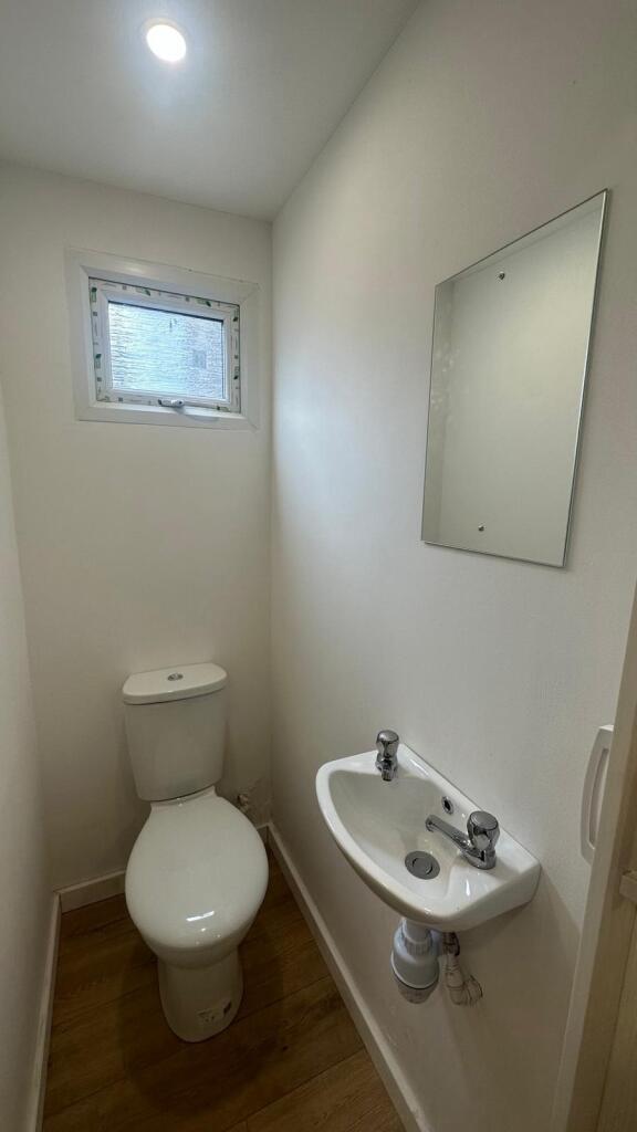 Bright and clean small toilet with white fixtur...