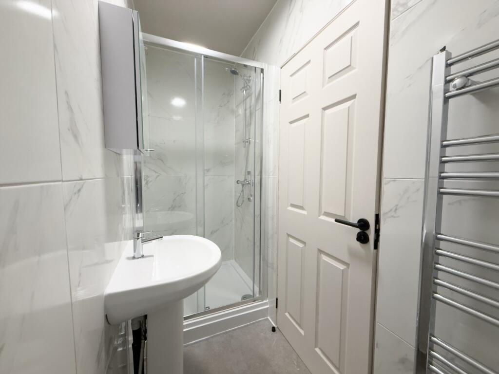 Bright, modern bathroom with a glass shower enc...