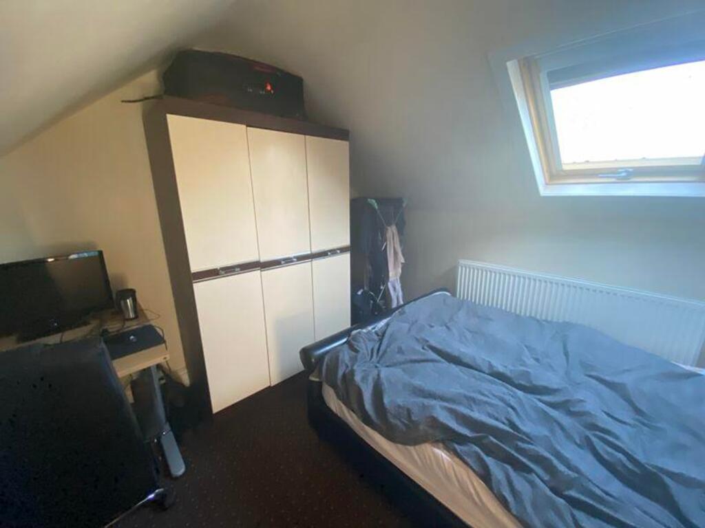 A cozy double bedroom featuring a fitted wardro...