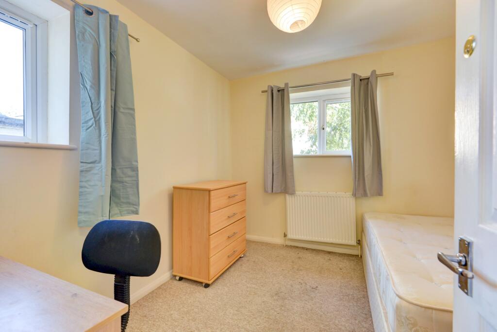 A modestly sized, tidy single bedroom featuring...