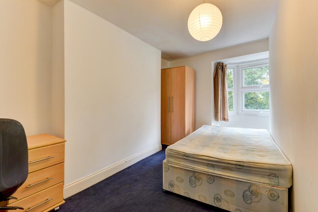 A bright and tidy single bedroom featuring a co...