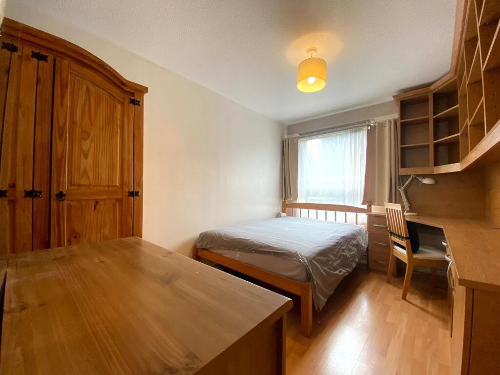 A cozy double bedroom featuring natural wood fu...