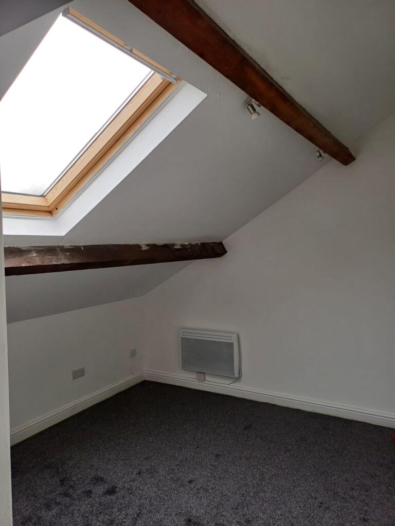 A cozy attic bedroom with a sloped ceiling illu...