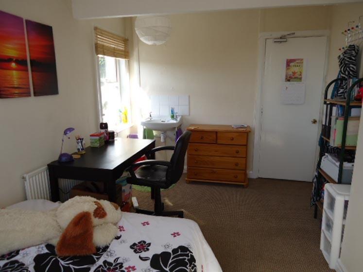 A comfortable bedroom featuring a bed with plus...