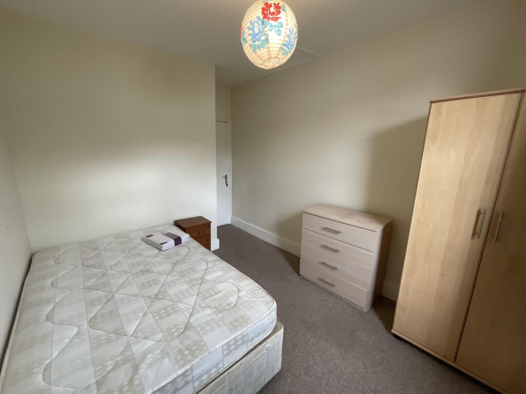 A neat and simple single bedroom featuring a co...