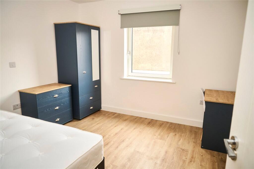 A clean and simple bedroom featuring light wood...