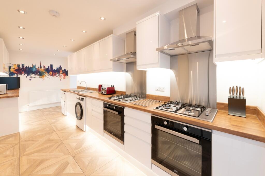 A modern and immaculate kitchen featuring sleek...
