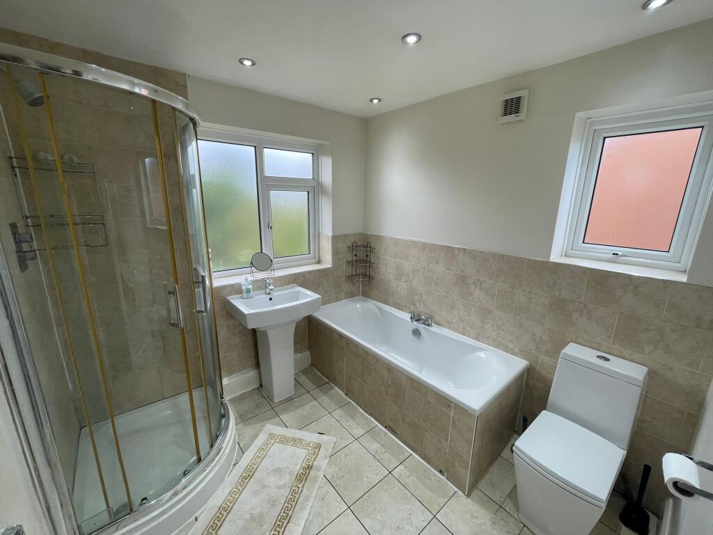 A bright, modern bathroom featuring a spacious ...