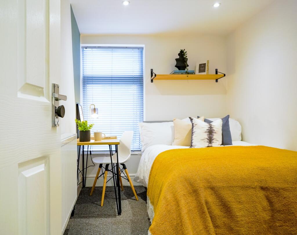 A bright, cozy bedroom featuring a comfortable ...