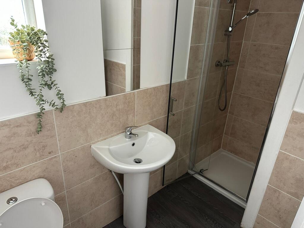 A modern, clean bathroom featuring a small sink...