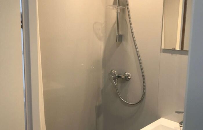 A clean, modern bathroom with a wall-mounted sh...
