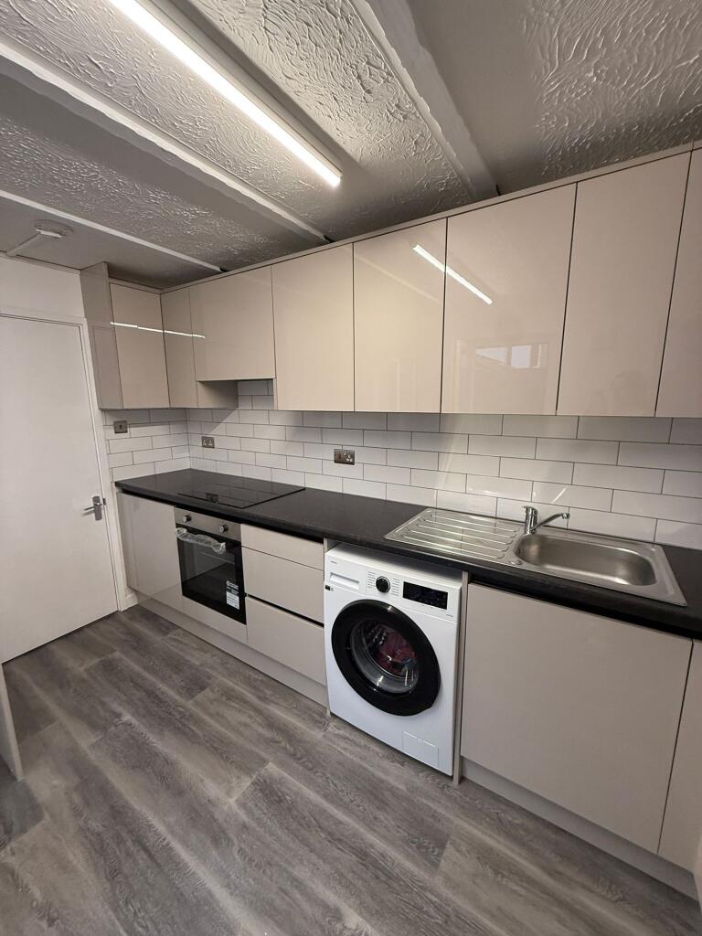This modern kitchen features sleek cabinetry an...