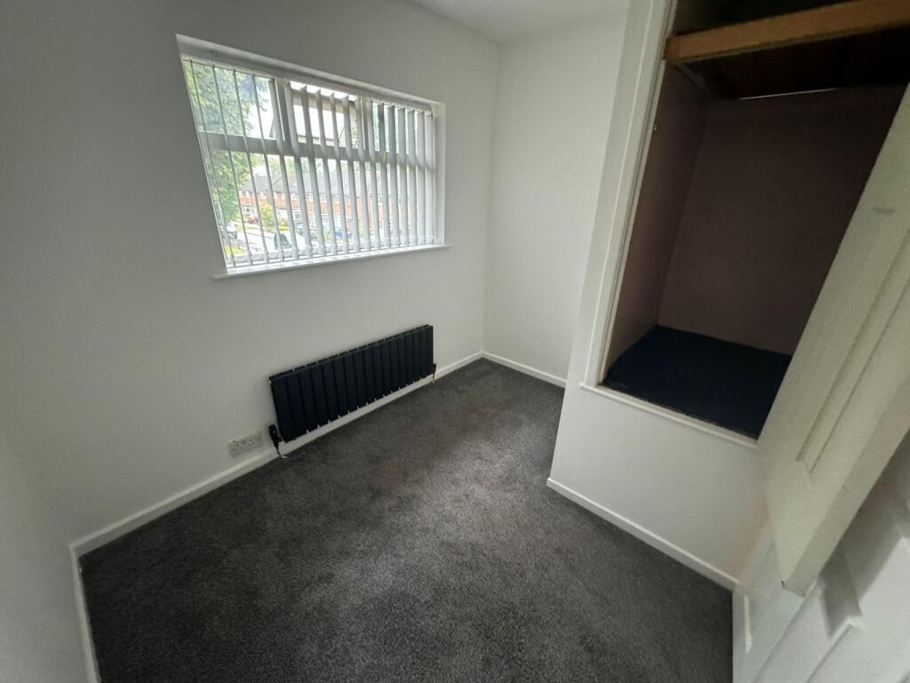 A cozy single bedroom with a window providing n...