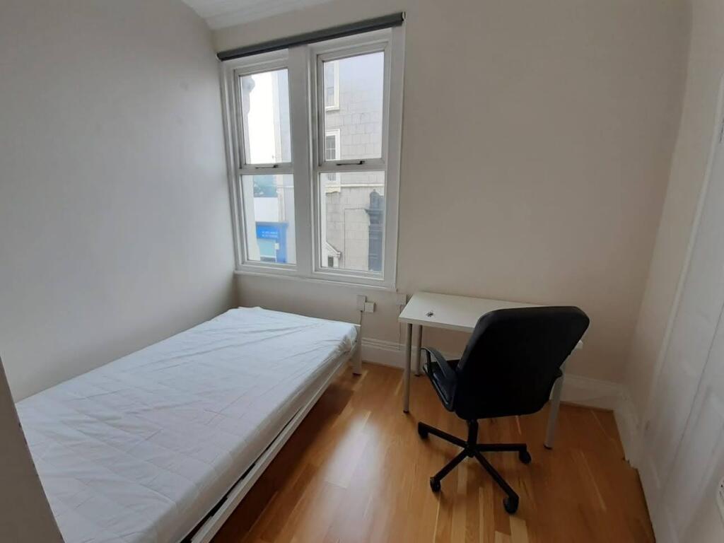Bright single bedroom with a large window, simp...