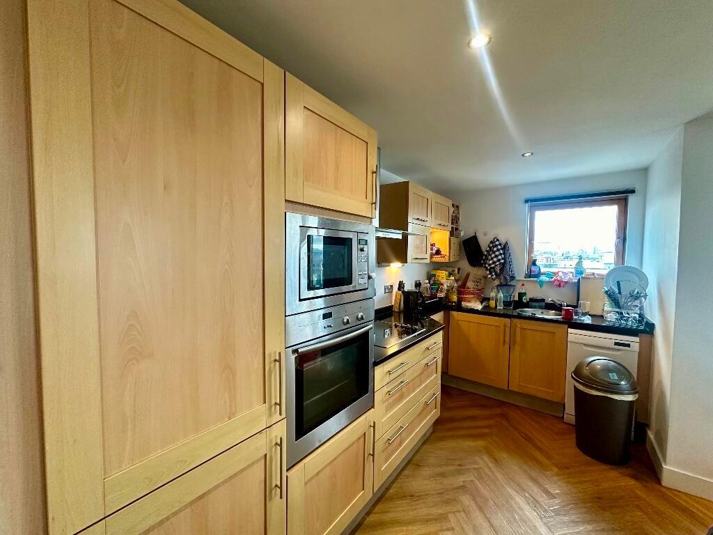 Bright kitchen featuring wooden cabinetry, buil...