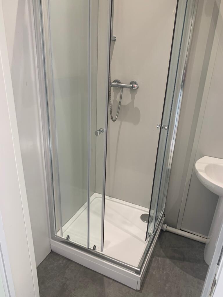 Modern shower area featuring sleek glass doors ...