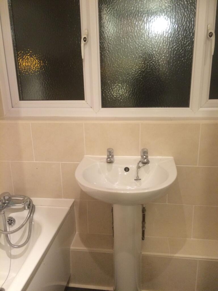 A neat and tidy bathroom featuring a white pede...