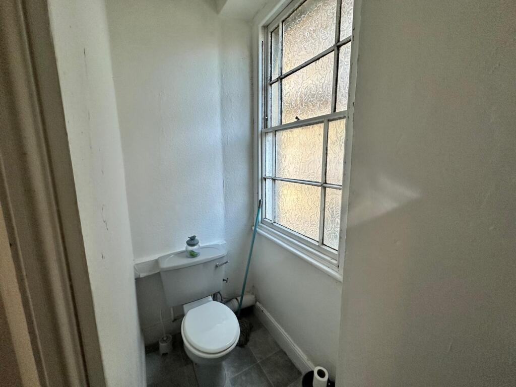 A bright and tidy single toilet with natural li...