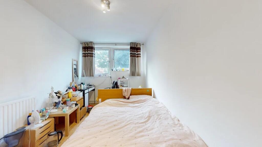 A cozy double bedroom featuring a large window ...