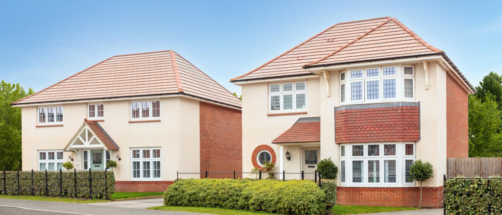 Two modern detached houses with cream and red brick exteriors, pitched tiled roofs, and white-framed