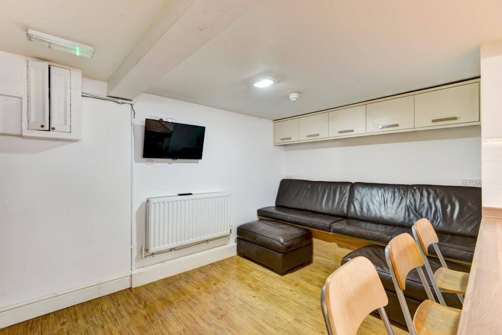 A cozy communal lounge featuring a dark leather...