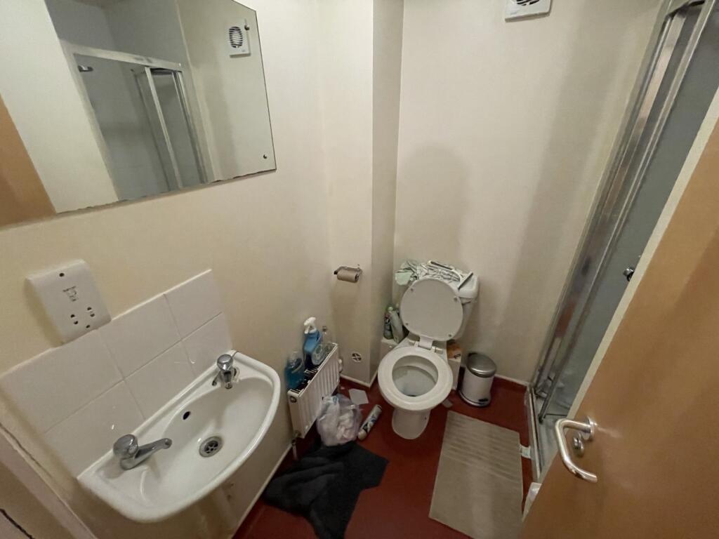 A compact bathroom featuring a white sink with ...