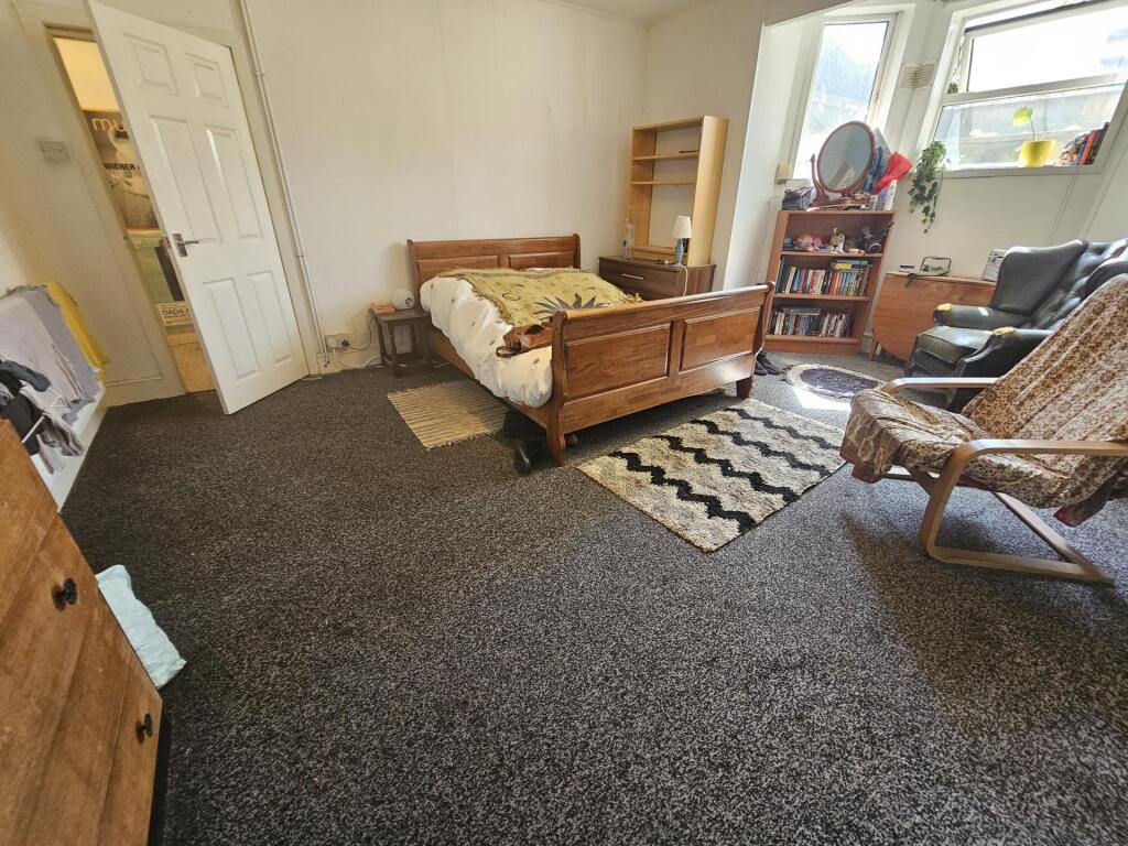 A spacious master bedroom featuring a double be...