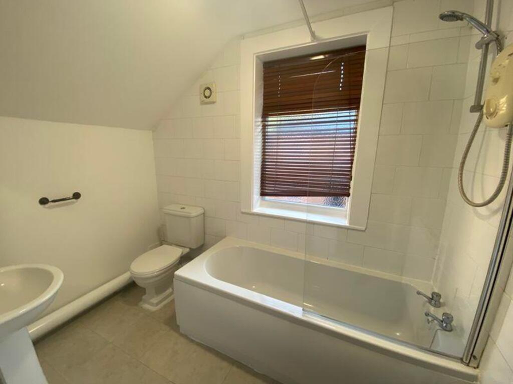 A spacious and bright bathroom featuring a comf...