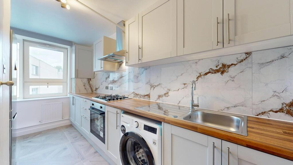 A modern and clean kitchen featuring sleek whit...