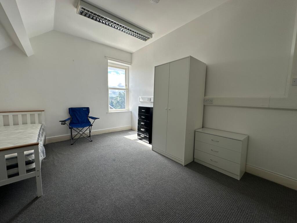 A bright and tidy bedroom featuring a single be...