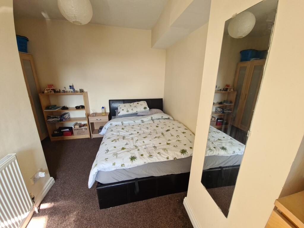 A well-lit double bedroom featuring a comfortab...