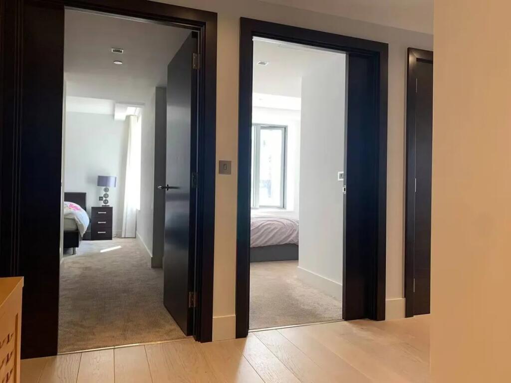 A clean and modern hallway featuring light wood...