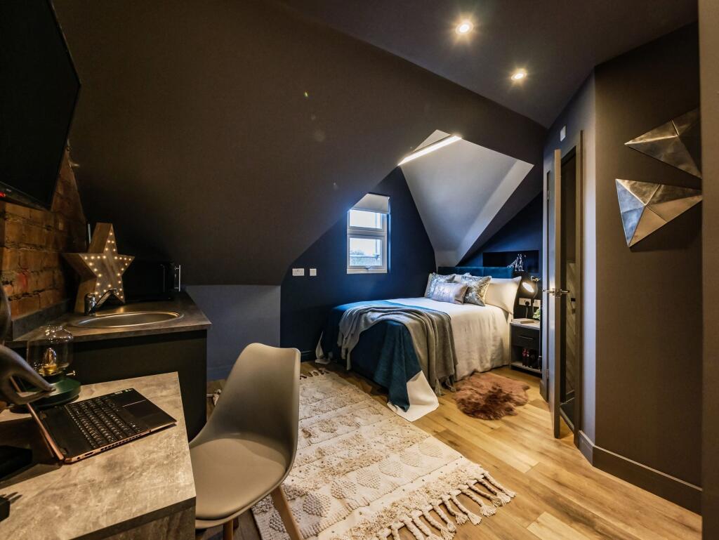 A stylish and cozy attic master bedroom featuri...