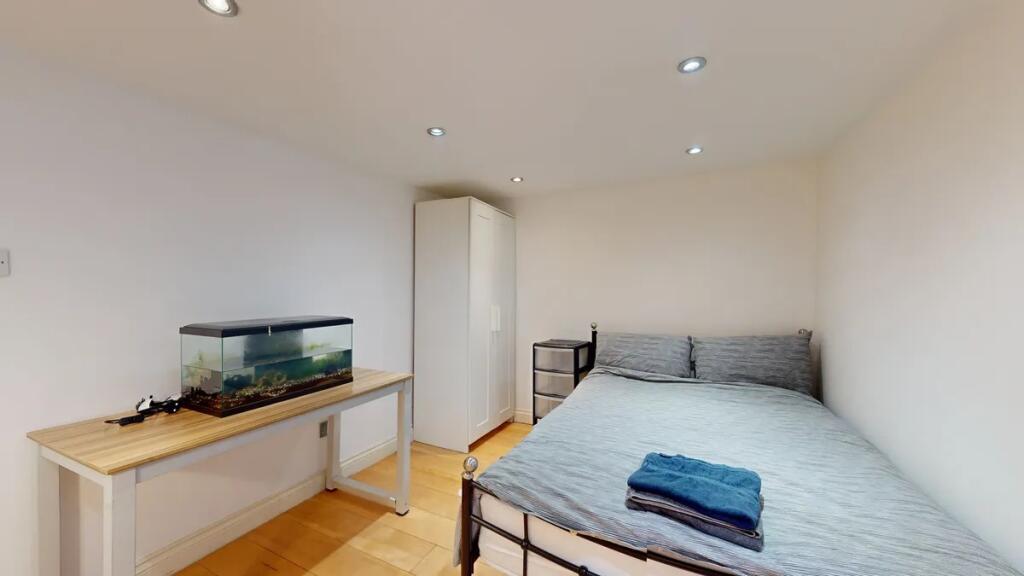 A neat double bedroom featuring a comfortable m...