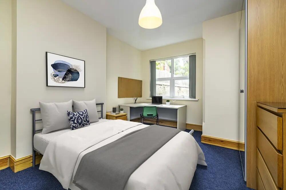 A cozy double bedroom featuring a neatly made b...