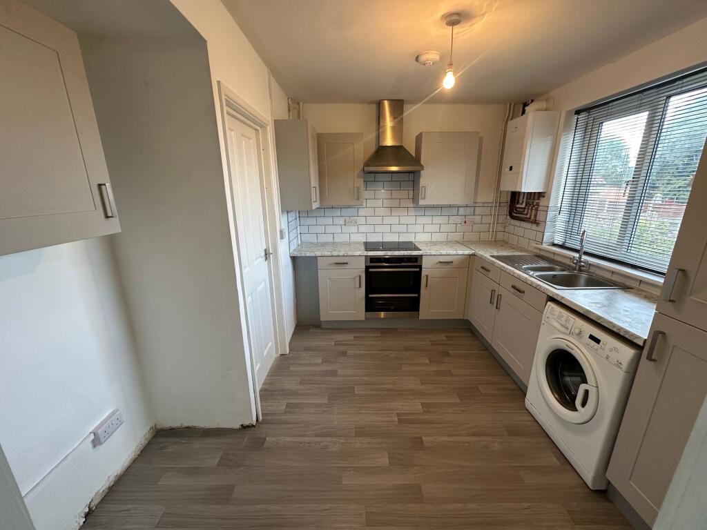 Bright and clean kitchen with modern cabinetry,...