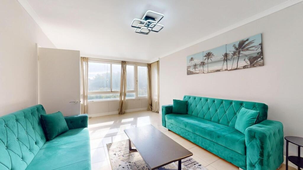 Bright and spacious living room featuring large...