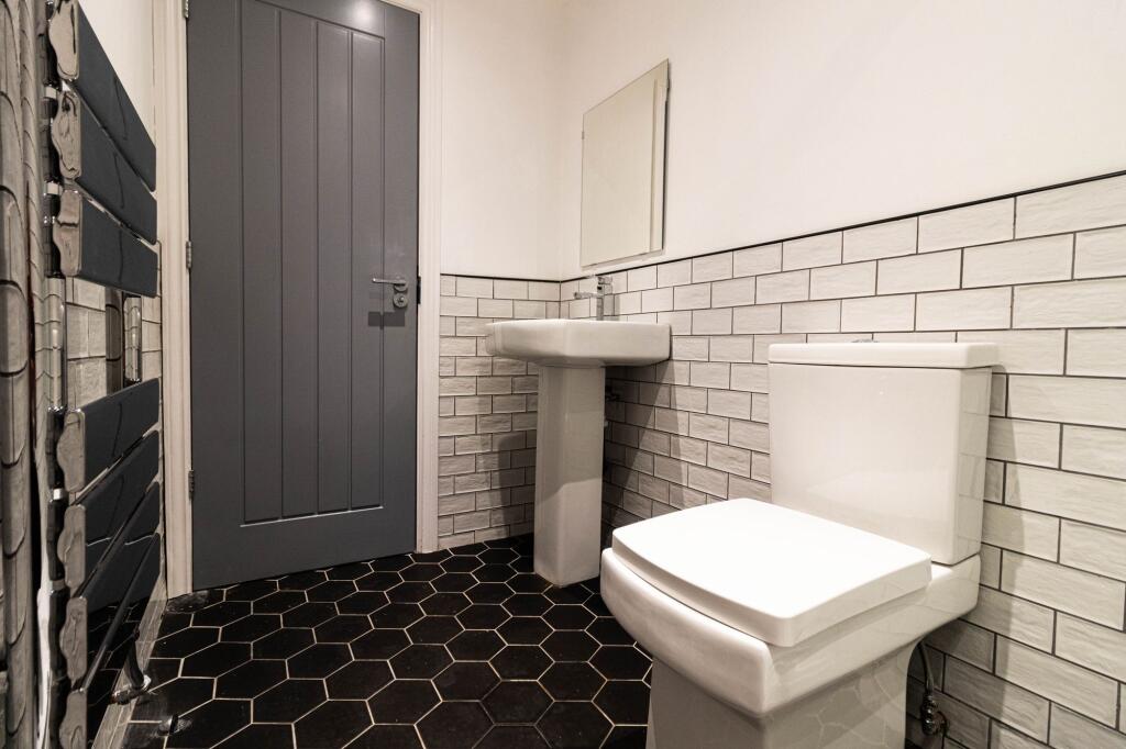 Modern, clean bathroom featuring a white toilet...