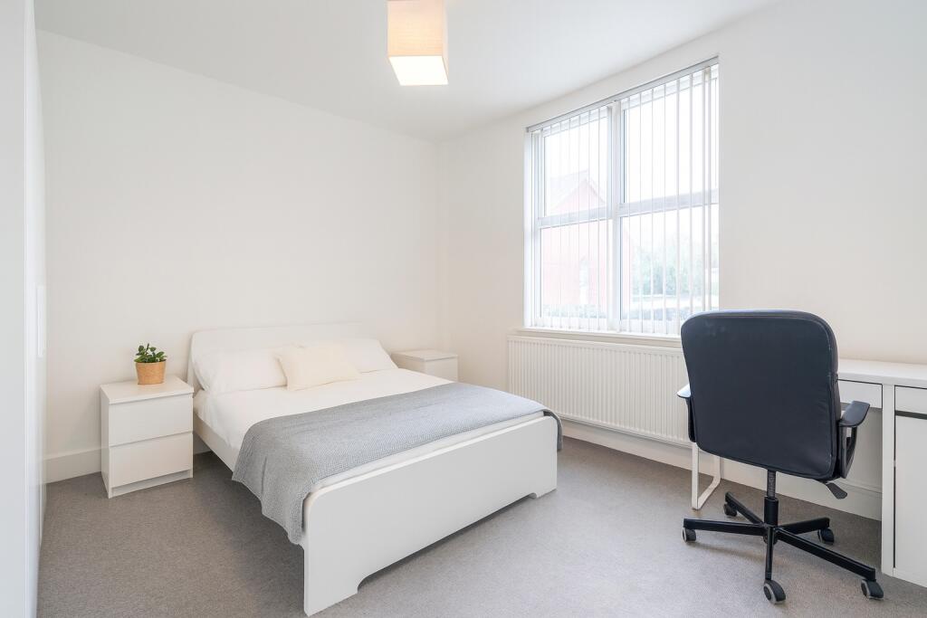 Bright and clean master bedroom featuring a com...