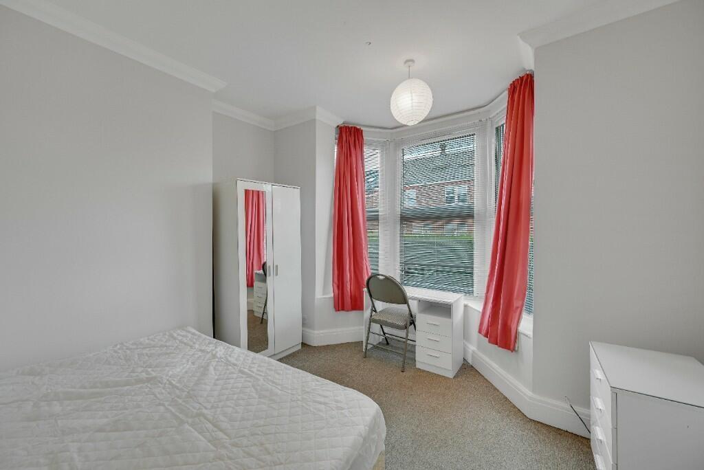 A bright double bedroom featuring a large bay w...