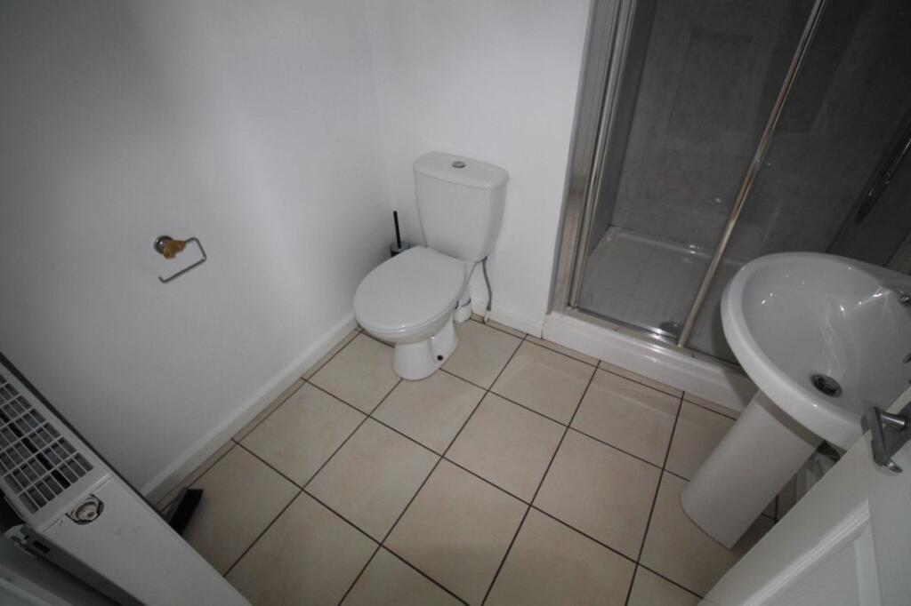 A neat and functional bathroom featuring a whit...