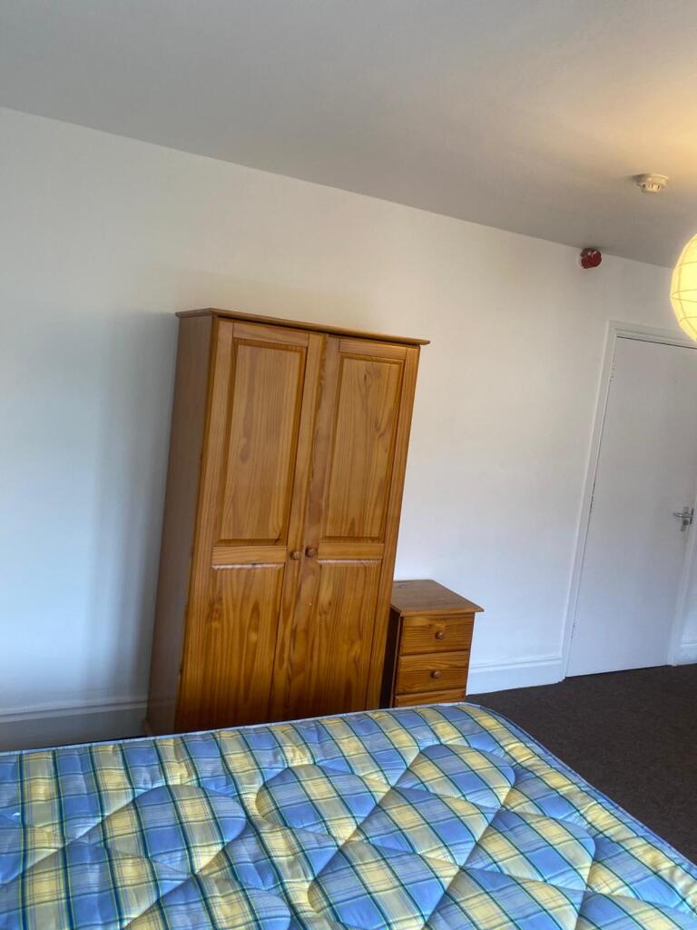 A simple and tidy double bedroom featuring a wo...